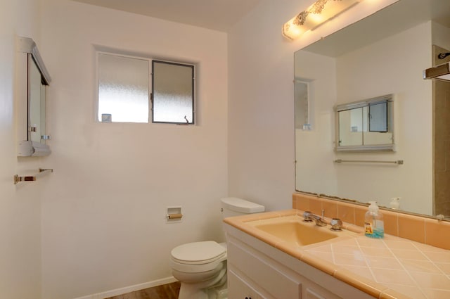 bathroom featuring wood-type flooring, vanity, and toilet