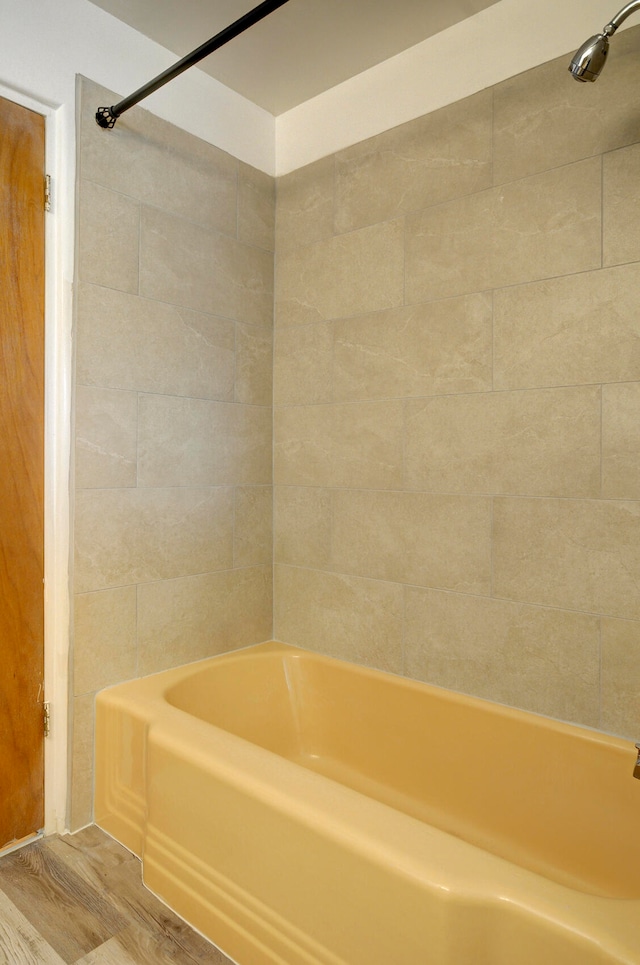 bathroom featuring wood-type flooring and tiled shower / bath combo