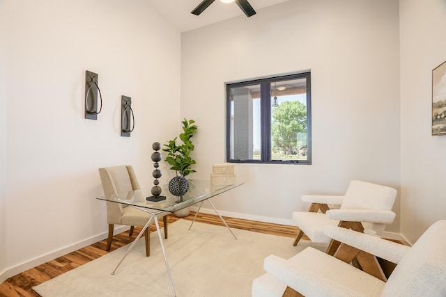 living area with hardwood / wood-style floors and ceiling fan