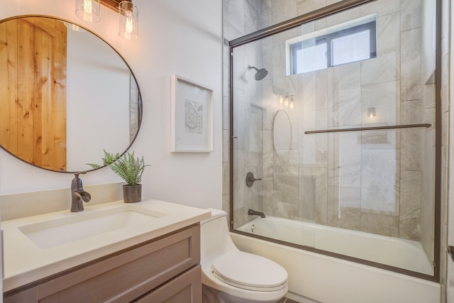 full bathroom featuring vanity, toilet, and bath / shower combo with glass door