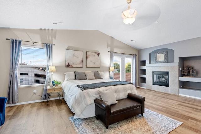 bedroom featuring wood-type flooring, lofted ceiling, and a fireplace