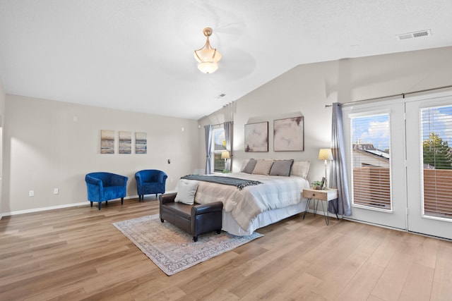 bedroom featuring a textured ceiling, lofted ceiling, light wood-type flooring, and access to exterior