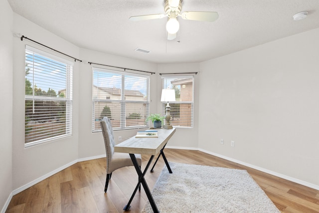 office with light hardwood / wood-style flooring, a textured ceiling, and ceiling fan