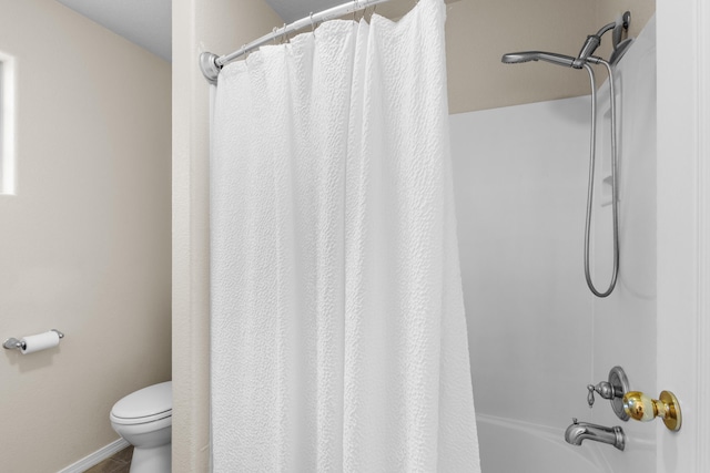 bathroom featuring shower / tub combo with curtain and toilet