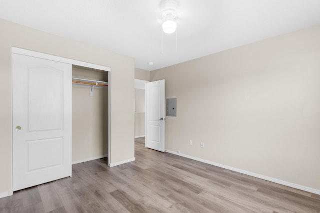 unfurnished bedroom featuring a closet, light hardwood / wood-style floors, and electric panel