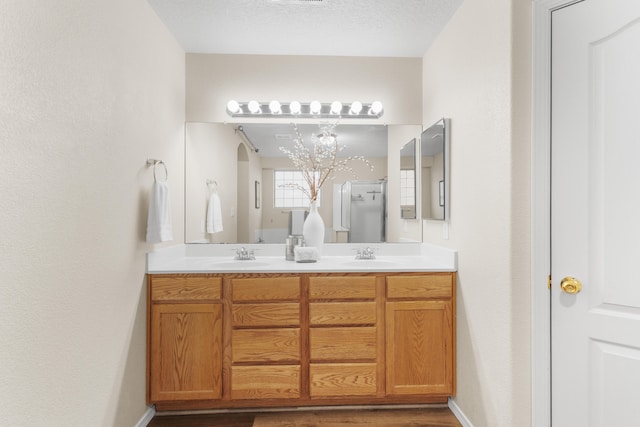 bathroom featuring vanity, hardwood / wood-style floors, and a textured ceiling