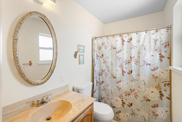 bathroom with curtained shower, vanity, and toilet