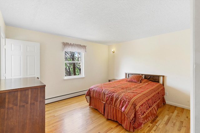 bedroom featuring a baseboard radiator, a textured ceiling, and light hardwood / wood-style flooring