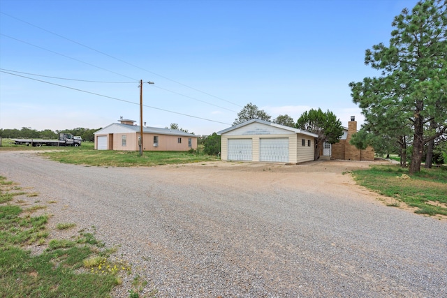 view of front of home featuring a garage and an outbuilding