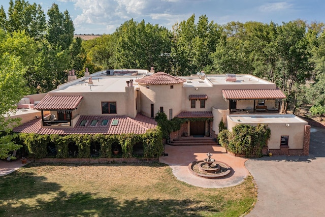 view of front facade with a patio, a jacuzzi, and a front yard