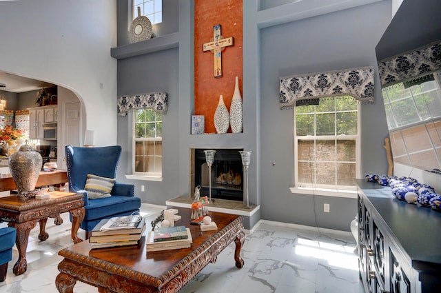 living room featuring a towering ceiling and plenty of natural light