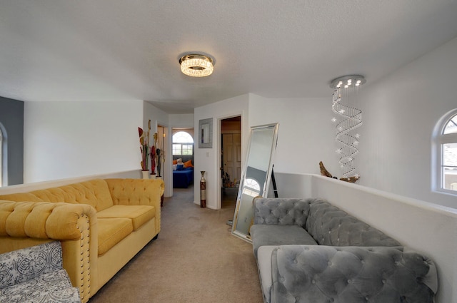 living room featuring a textured ceiling, a chandelier, and light colored carpet