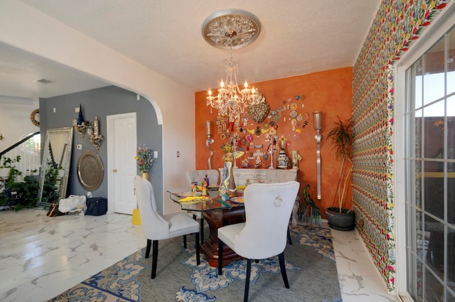 dining area with a notable chandelier and a textured ceiling