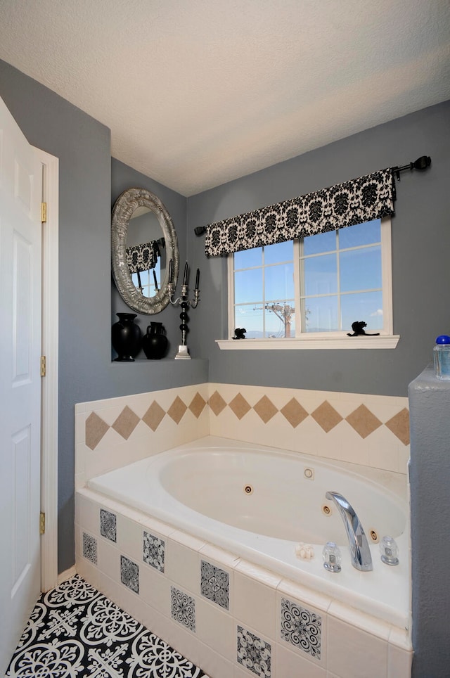 bathroom with tiled tub, tile patterned floors, and a textured ceiling