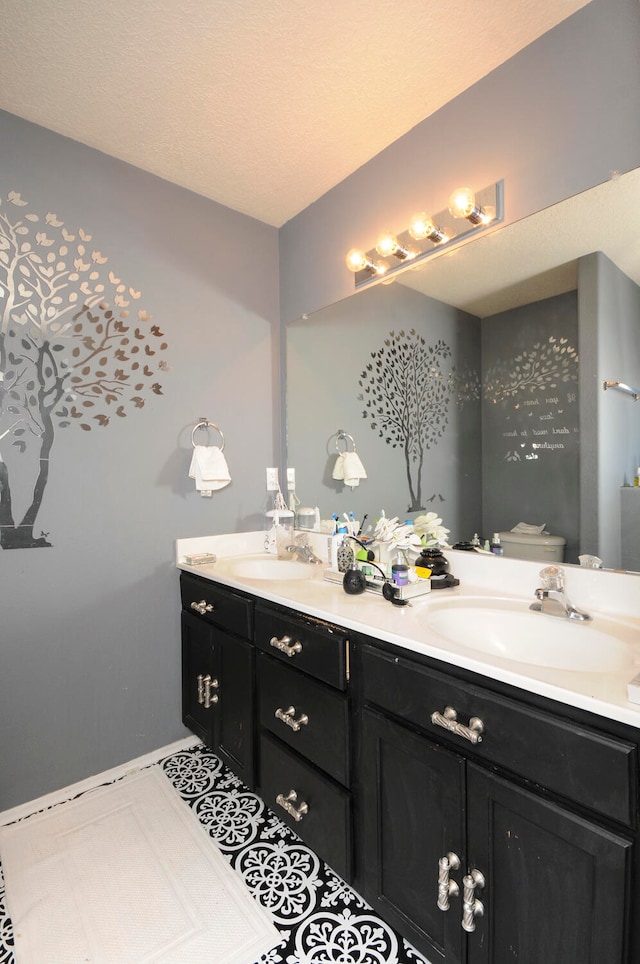 bathroom featuring vanity, tile patterned flooring, toilet, and a textured ceiling