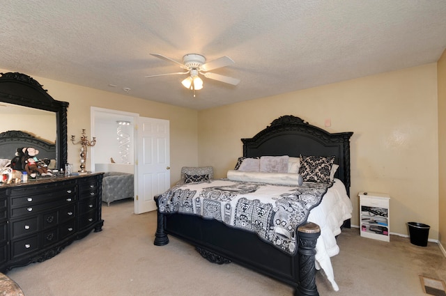 carpeted bedroom featuring ceiling fan and a textured ceiling