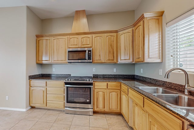 kitchen with appliances with stainless steel finishes, light brown cabinetry, light tile patterned floors, and sink