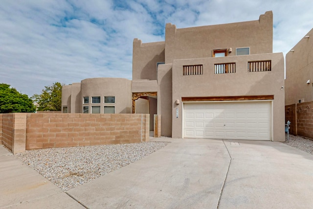 pueblo revival-style home featuring a garage