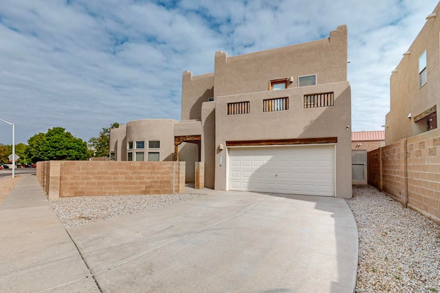 pueblo-style house featuring a garage