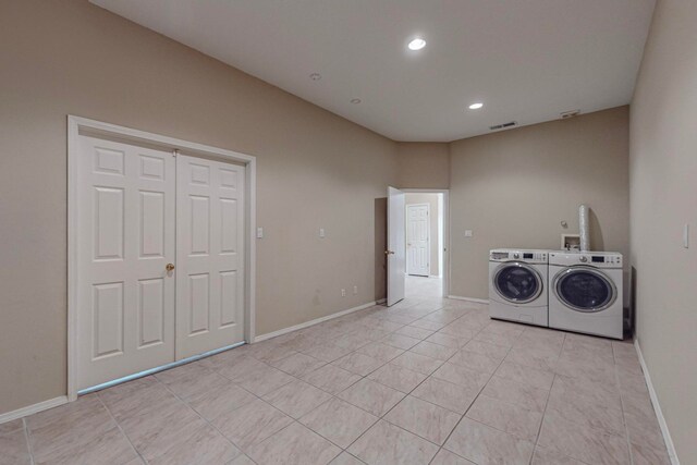 laundry area with light tile patterned floors and washing machine and clothes dryer