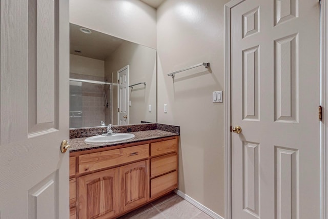 bathroom with tile patterned floors, walk in shower, and vanity