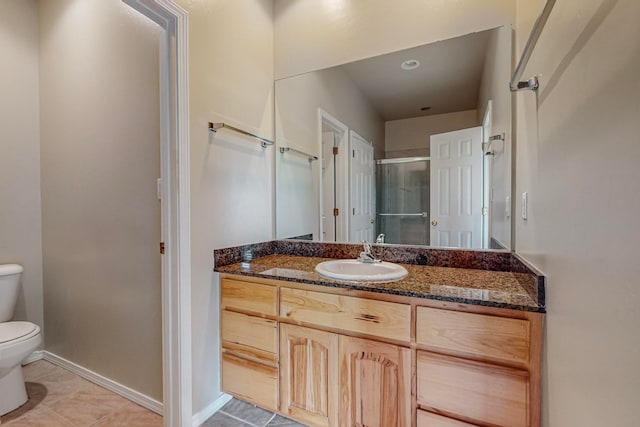 bathroom with vanity, toilet, an enclosed shower, and tile patterned floors