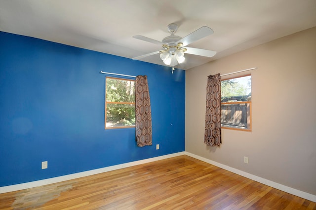 empty room with ceiling fan, light wood-type flooring, and a healthy amount of sunlight