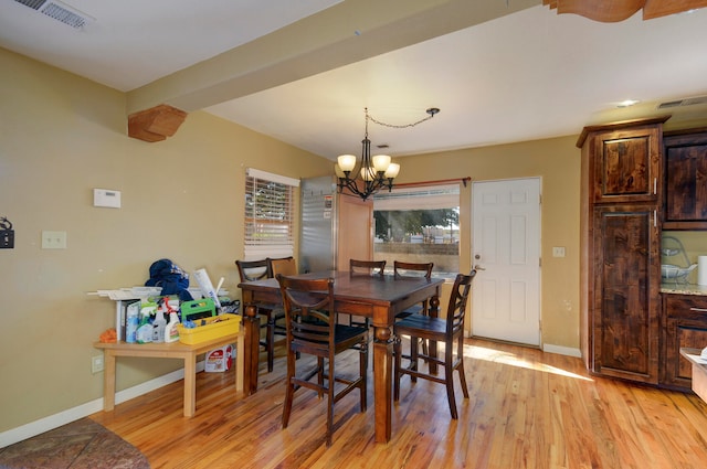 dining room with light wood-type flooring and a chandelier