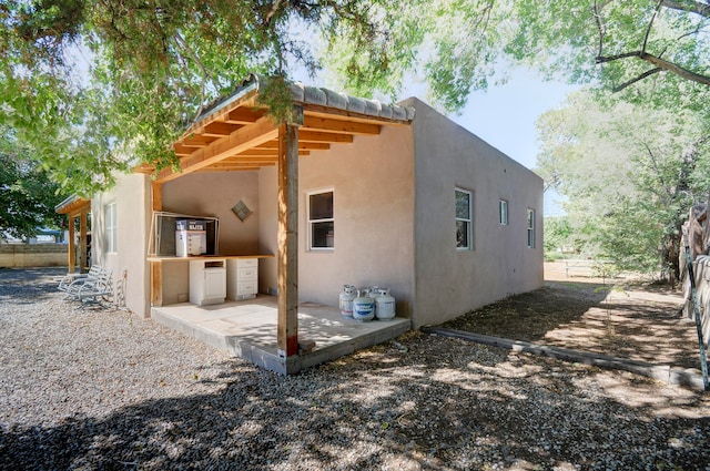 view of property exterior with a patio area and exterior kitchen