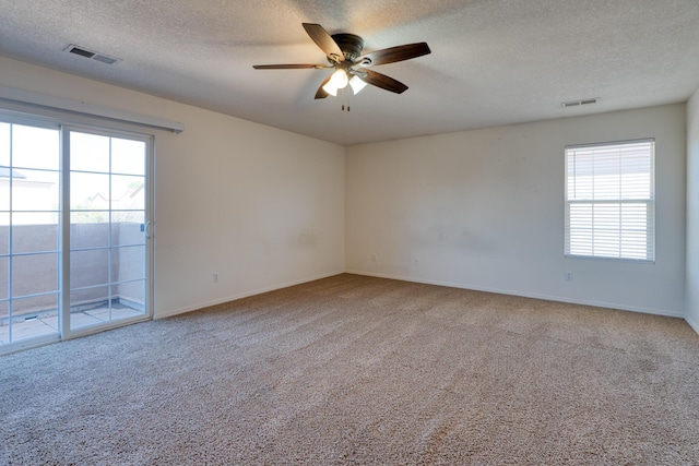 carpeted empty room with a textured ceiling and ceiling fan