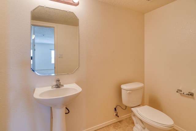 bathroom featuring toilet and a textured ceiling