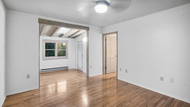 empty room featuring vaulted ceiling with beams, hardwood / wood-style floors, a baseboard heating unit, and ceiling fan