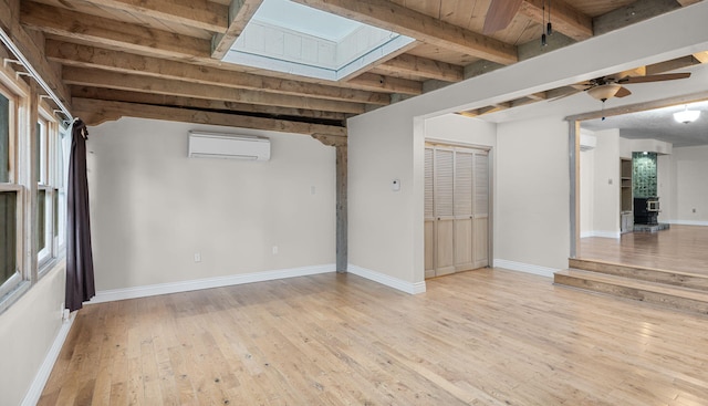 basement with an AC wall unit, wood ceiling, light hardwood / wood-style floors, and ceiling fan