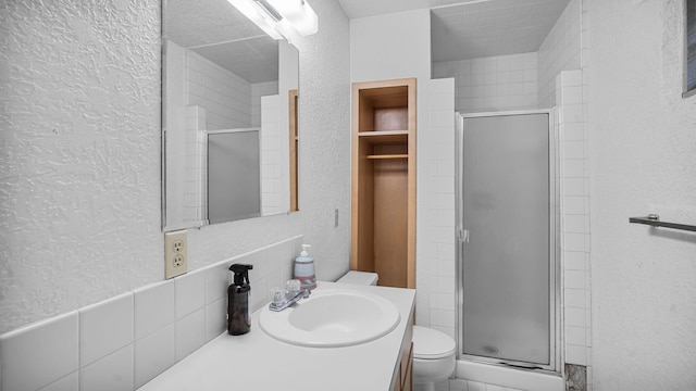 bathroom with walk in shower, vanity, toilet, and a textured ceiling