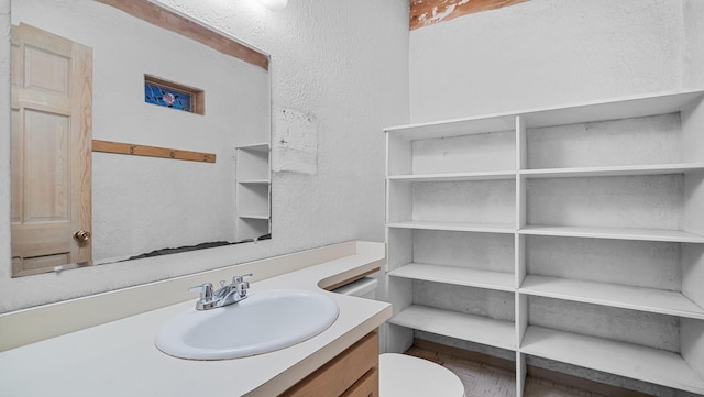 bathroom with vanity, toilet, and hardwood / wood-style flooring