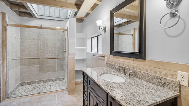 bathroom featuring walk in shower, beam ceiling, tile patterned flooring, and vanity