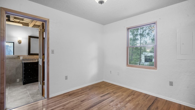 unfurnished bedroom featuring light hardwood / wood-style floors and electric panel