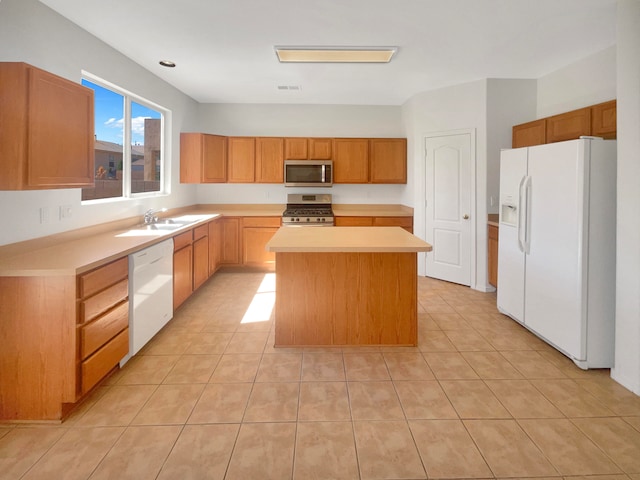 kitchen featuring a center island, light tile patterned floors, sink, and appliances with stainless steel finishes