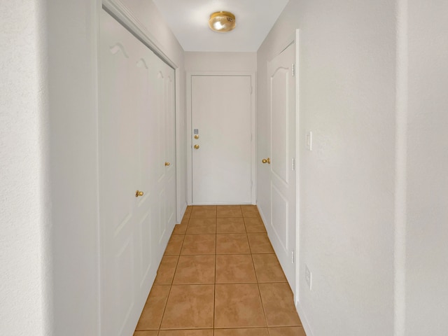 hall with light tile patterned floors