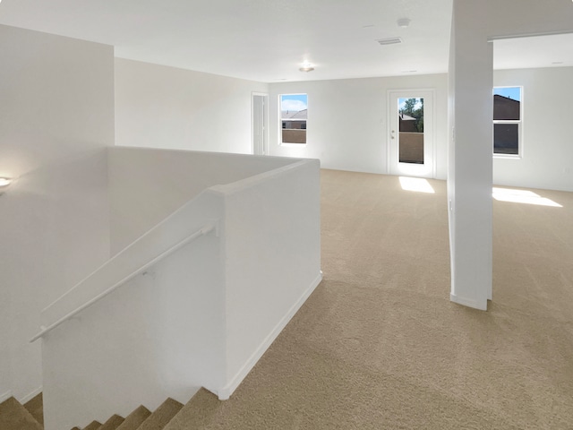 hall with light colored carpet