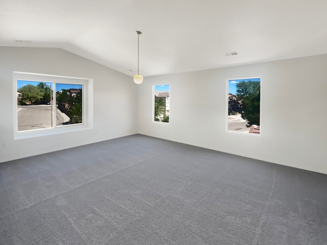 empty room with dark colored carpet and lofted ceiling