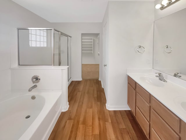 bathroom featuring plus walk in shower, hardwood / wood-style floors, and vanity