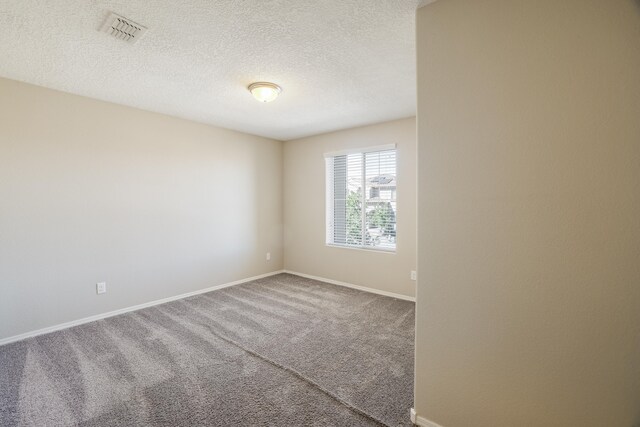 carpeted spare room featuring a textured ceiling