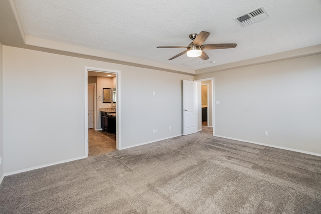 carpeted spare room featuring ceiling fan and a textured ceiling