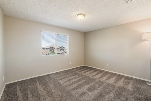 spare room featuring a textured ceiling and carpet floors