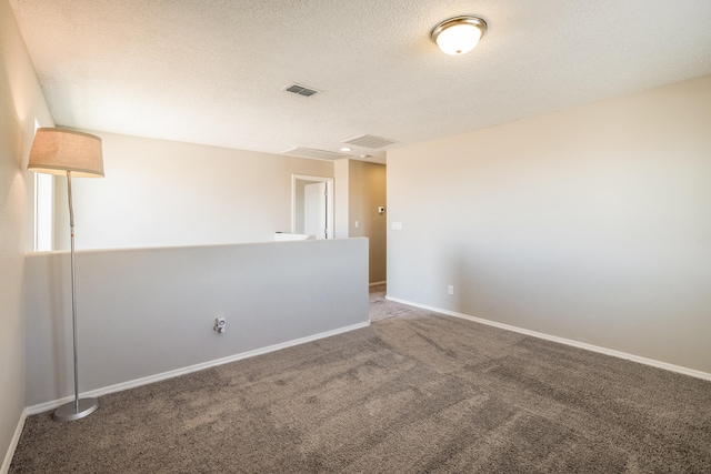 empty room with a textured ceiling and carpet floors