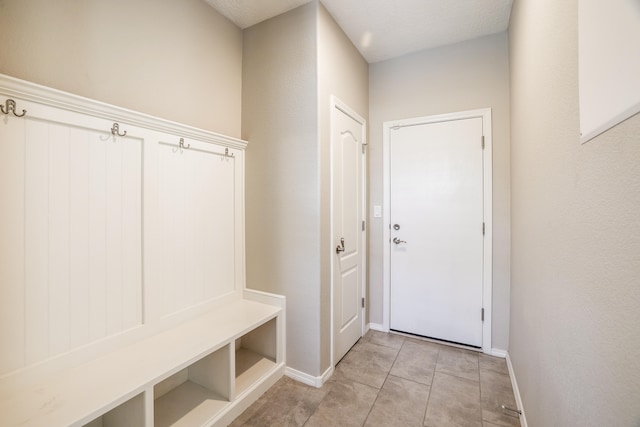 mudroom with a textured ceiling and light tile patterned floors