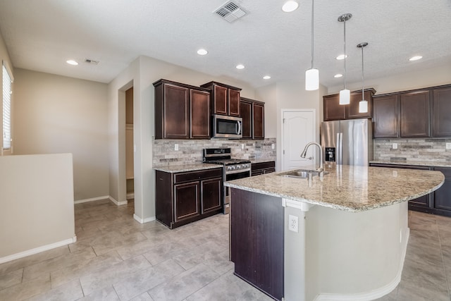 kitchen featuring a center island with sink, appliances with stainless steel finishes, sink, and a textured ceiling