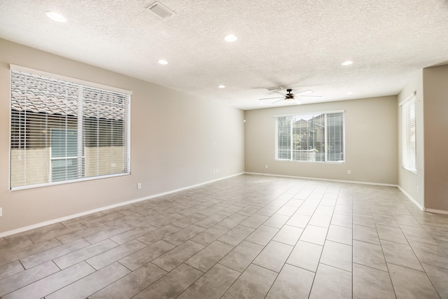 tiled spare room featuring ceiling fan and a textured ceiling