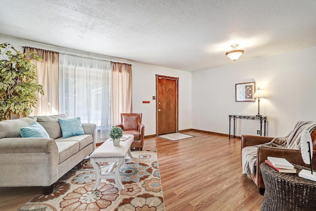 living room with light hardwood / wood-style floors and a textured ceiling